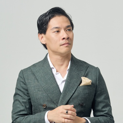 Portrait of Dr Eugene Seow, contemporary music educator and researcher, wearing a green suit against a neutral background.
