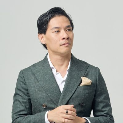 Portrait of Dr Eugene Seow, contemporary music educator and researcher, wearing a green suit against a neutral background.