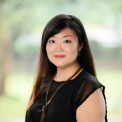 Image of an Asian woman with long black hair and a sleeveless black dress. 